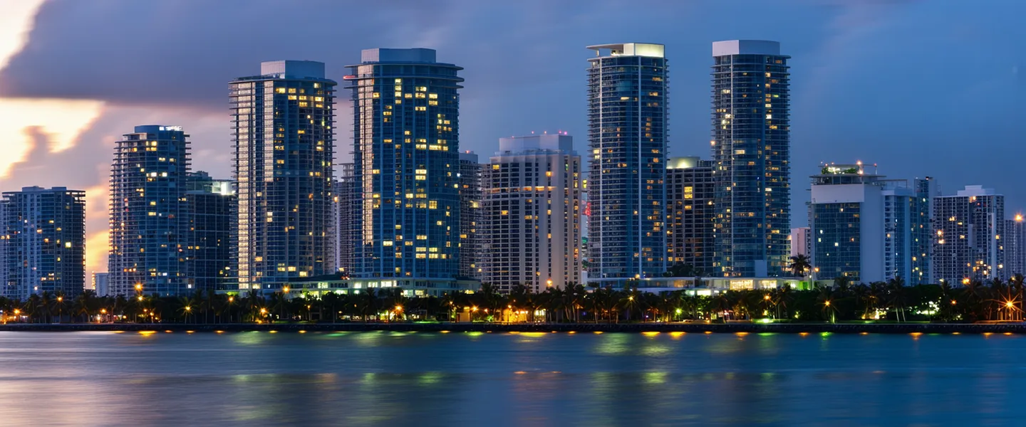 Brickell Key Drive, Miami — the financial district where Valuevynt is headquartered, with commercial office towers reflecting on Biscayne Bay